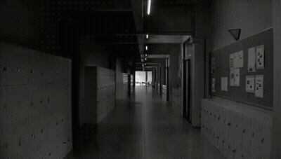 A Black And White Photo Of A Long Hallway In A School With Lockers And A Bulletin Board . GIF