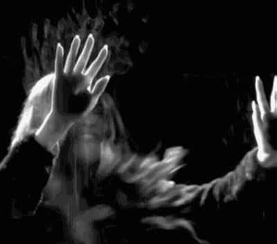 A Black And White Photo Of A Man And A Woman Behind A Glass Door . GIF