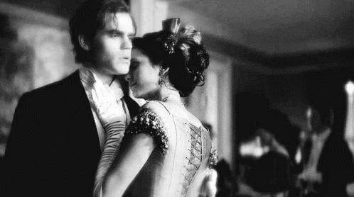 A Black And White Photo Of A Man And A Woman Dancing Together . GIF