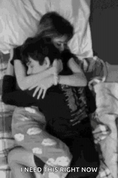 A Black And White Photo Of A Man And A Woman Hugging Each Other . GIF