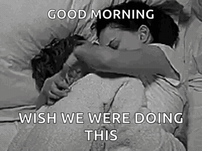 A Black And White Photo Of A Man And A Woman Hugging Each Other In Bed . GIF