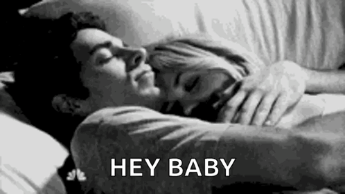 A Black And White Photo Of A Man And A Woman Hugging Each Other In Bed . GIF