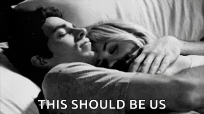A Black And White Photo Of A Man And A Woman Hugging Each Other In Bed . GIF