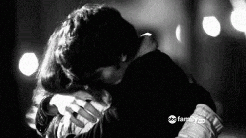 A Black And White Photo Of A Man And A Woman Hugging Each Other . GIF