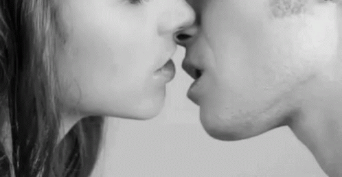 A Black And White Photo Of A Man And A Woman Kissing . GIF