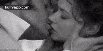 A Black And White Photo Of A Man And A Woman Kissing . GIF