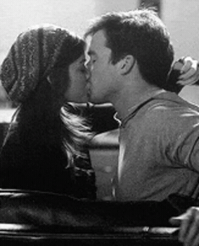 A Black And White Photo Of A Man And A Woman Kissing In A Car . GIF