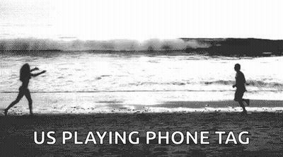 A Black And White Photo Of A Man And A Woman Playing Frisbee On A Beach . GIF