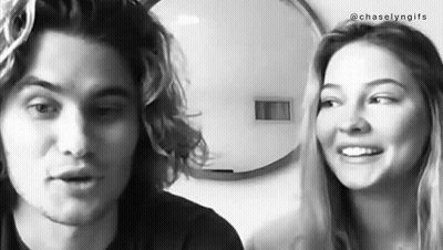 A Black And White Photo Of A Man And A Woman Smiling At Each Other . GIF
