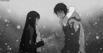 A Black And White Photo Of A Man And A Woman Standing In The Snow . GIF