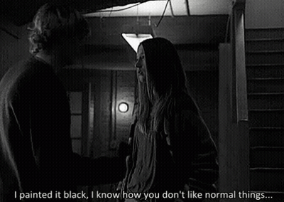 A Black And White Photo Of A Man And A Woman Standing Next To Each Other In A Dark Room . GIF