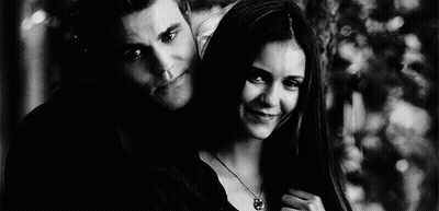 A Black And White Photo Of A Man And A Woman Standing Next To Each Other . GIF