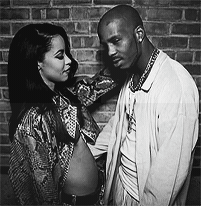 A Black And White Photo Of A Man And A Woman Standing Next To Each Other GIF