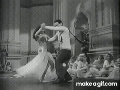 A Black And White Photo Of A Man And Woman Dancing In A Room . GIF