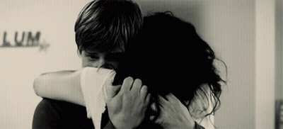 A Black And White Photo Of A Man And Woman Hugging With The Word Lum Written On The Wall Behind Them GIF