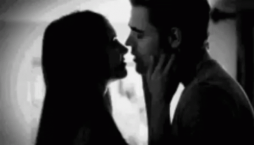 A Black And White Photo Of A Man And Woman Kissing Each Other . GIF