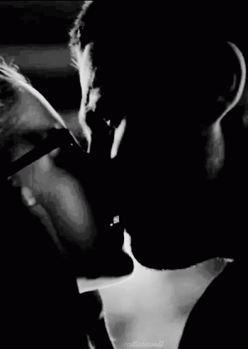 A Black And White Photo Of A Man And Woman Kissing Each Other . GIF