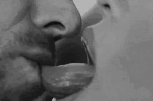 A Black And White Photo Of A Man And Woman Kissing Each Other . GIF