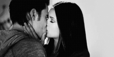 A Black And White Photo Of A Man And Woman Kissing Each Other . GIF