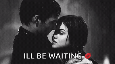 A Black And White Photo Of A Man And Woman Kissing In The Rain With The Words Ill Be Waiting Below Them GIF