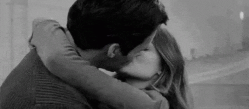 A Black And White Photo Of A Man And Woman Kissing . GIF