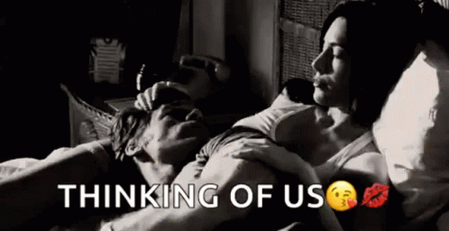 A Black And White Photo Of A Man And Woman Laying In Bed With The Words `` Thinking Of Us '' . GIF