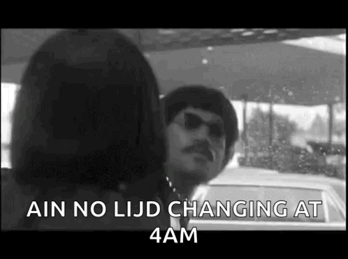 A Black And White Photo Of A Man And Woman Standing Next To Each Other In A Car . GIF
