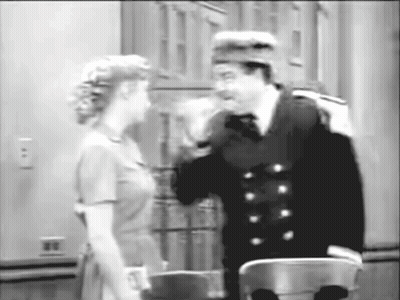 A Black And White Photo Of A Man And Woman Talking To Each Other GIF