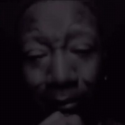 A Black And White Photo Of A Man Covering His Face GIF