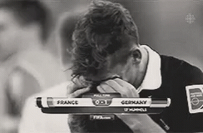 A Black And White Photo Of A Man Covering His Face While Watching A Game Between France And Germany GIF