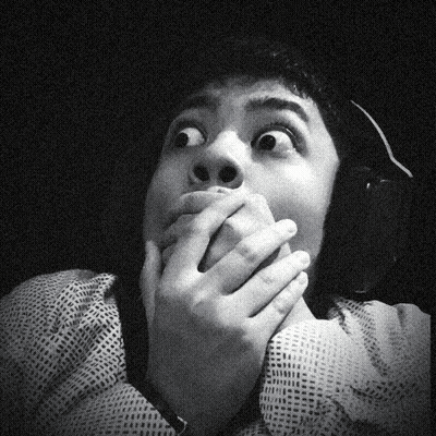 A Black And White Photo Of A Man Covering His Mouth GIF