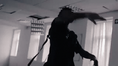 A Black And White Photo Of A Man Dancing In A Room With A Fire Exit Sign . GIF