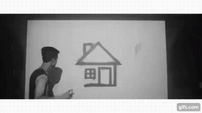 a black and white photo of a man drawing a house on a wall