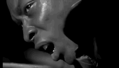 A Black And White Photo Of A Man Eating A Piece Of Food . GIF