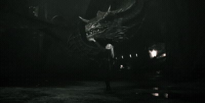 A Black And White Photo Of A Man Holding A Large Dragon GIF