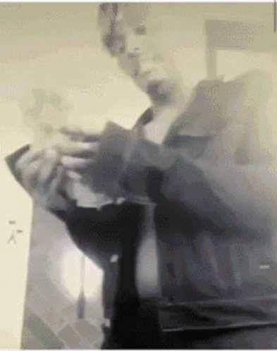 A Black And White Photo Of A Man Holding A Piece Of Paper GIF