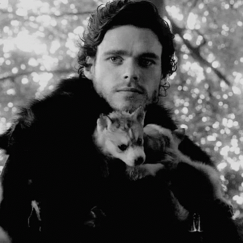 A Black And White Photo Of A Man Holding A Puppy . GIF