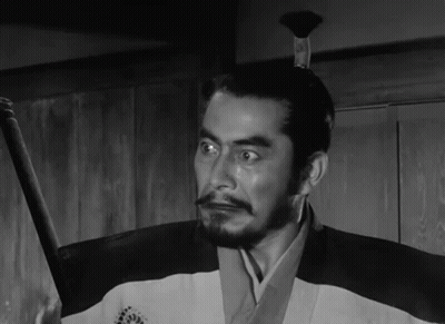 A Black And White Photo Of A Man Holding A Sword GIF