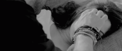 A Black And White Photo Of A Man Holding A Woman 'S Hand While Laying On A Bed . GIF