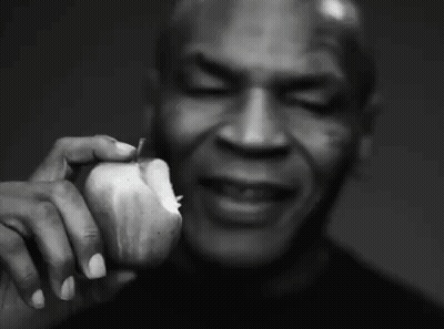 A Black And White Photo Of A Man Holding An Apple GIF