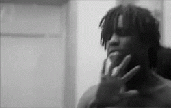 A Black And White Photo Of A Man Holding His Hand To His Face . GIF