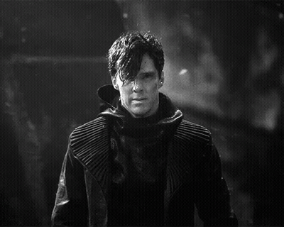 A Black And White Photo Of A Man In A Black Coat GIF