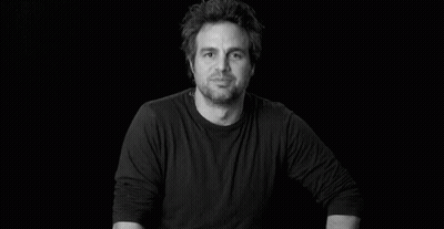 A Black And White Photo Of A Man In A Black Shirt Smiling . GIF