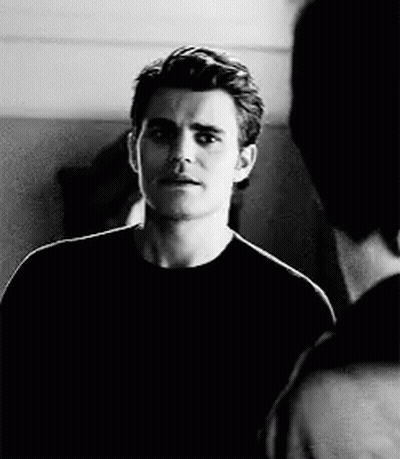 A Black And White Photo Of A Man In A Black Shirt Talking To Another Man GIF