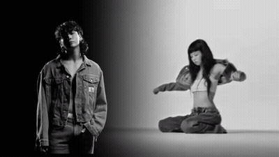 A Black And White Photo Of A Man In A Denim Jacket And A Woman In A Bra GIF