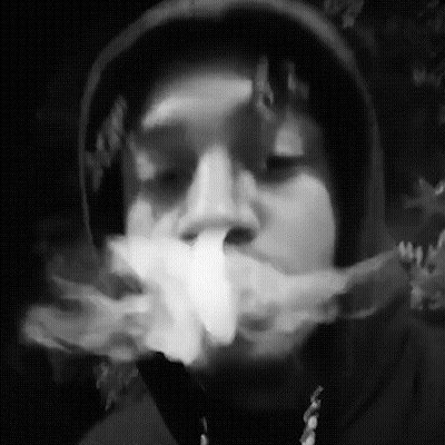 A Black And White Photo Of A Man In A Hoodie Smoking A Cigarette . GIF