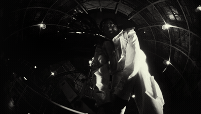 A Black And White Photo Of A Man In A Lab Coat With A Name Tag That Says ' A.j. ' On It GIF