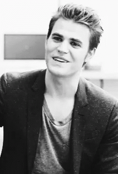 A Black And White Photo Of A Man In A Suit And A Gray Shirt . GIF