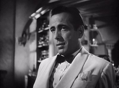 A Black And White Photo Of A Man In A Suit And Bow Tie GIF