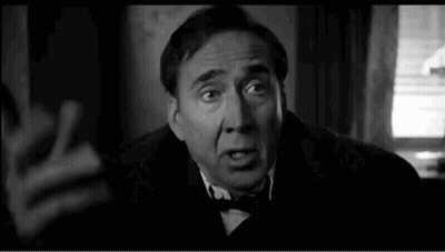 A Black And White Photo Of A Man In A Suit And Bow Tie Making A Funny Face . GIF